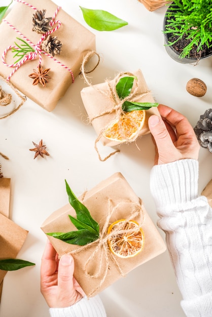 Manos femeninas decoran caja de regalo de navidad.