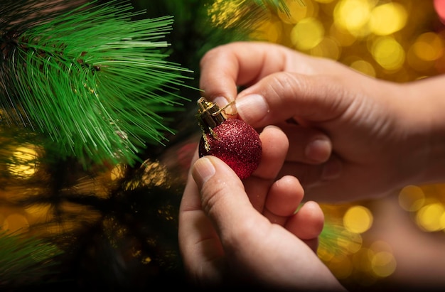 Foto manos femeninas decorando el árbol de navidad