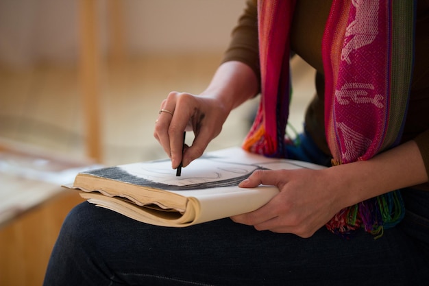 Manos femeninas dibuja con retrato de carboncillo en cuaderno de bocetos