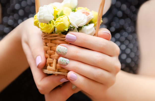 Manos femeninas con diseño de uñas morado claro