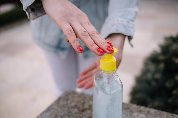 Manos femeninas con dispensador de bomba de gel desinfectante para manos
