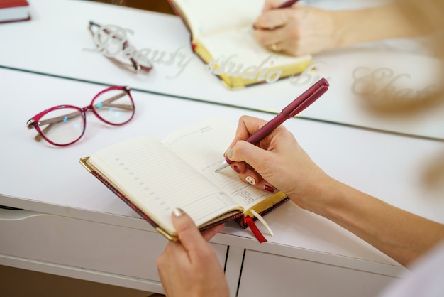 Las manos femeninas escriben con una pluma