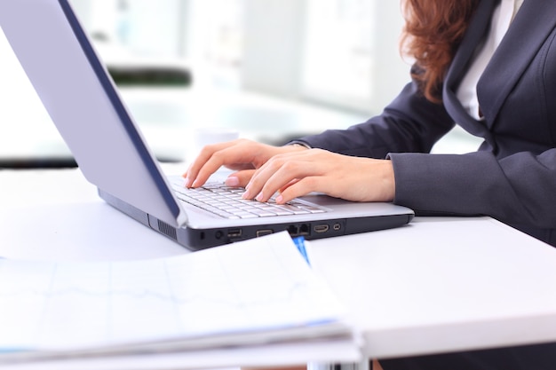 Manos femeninas escribiendo en una computadora portátil