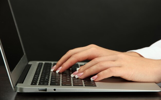 manos femeninas escribiendo en laptot de cerca