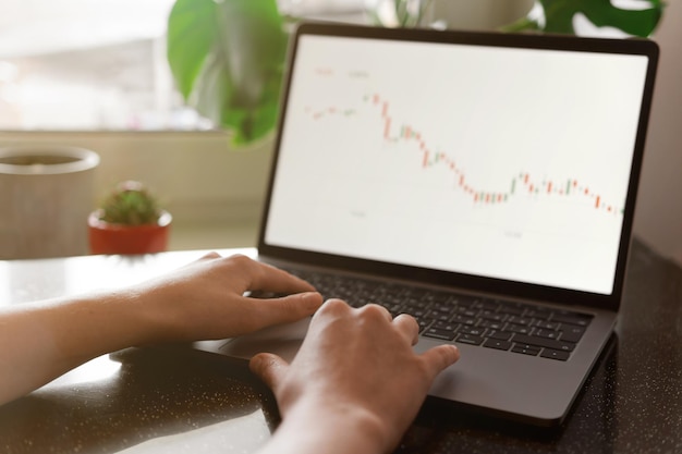 Manos femeninas escribiendo números de una computadora portátil análisis de inversiones concepto de comercio