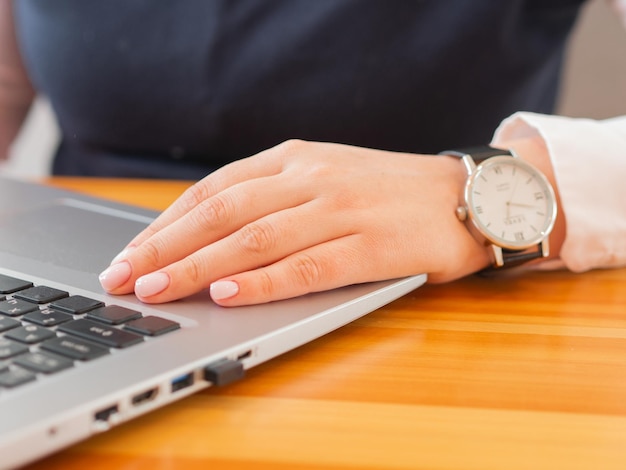 Manos femeninas escribiendo en el teclado del portátil, niña, reloj de pulsera blanco