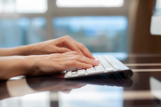 Foto manos femeninas escribiendo texto en el teclado mientras se intercambian mensajes