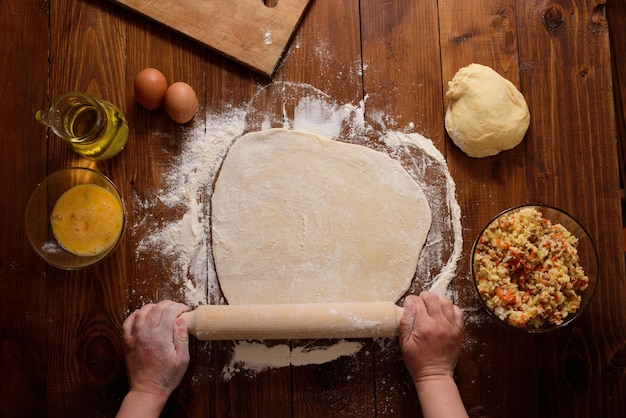 Las manos femeninas esculpen pasteles caseros sobre un fondo de madera