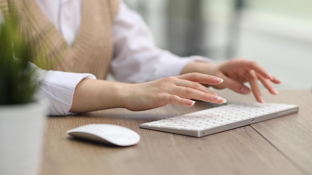 Las manos femeninas están escribiendo en un teclado de computadora