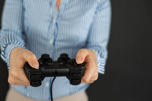 Foto manos femeninas con un gamepad. aislado sobre fondo negro