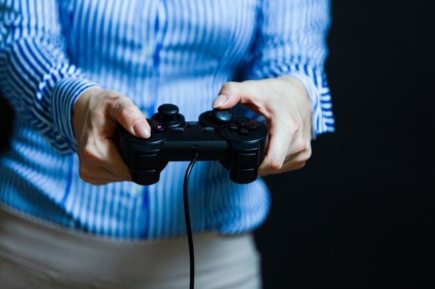 Manos femeninas con un gamepad. Aislado sobre fondo negro