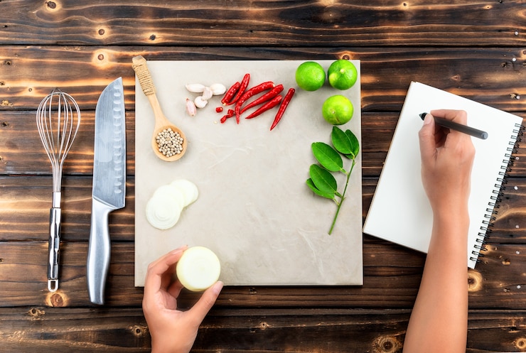 Foto las manos femeninas hacen notas en el libro de la dieta en la mesa de madera con ingredientes,