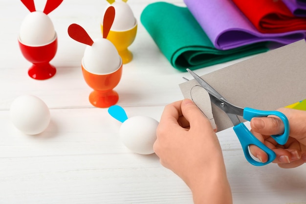 Manos femeninas haciendo decoración de Pascua