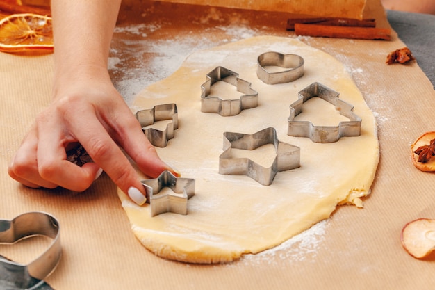 manos femeninas haciendo galletas de masa fresca en casa