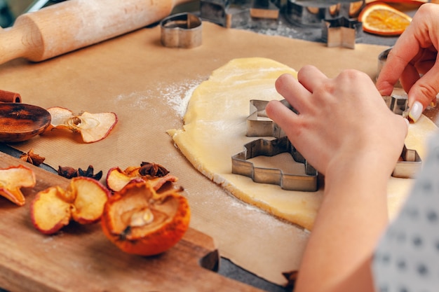 manos femeninas haciendo galletas de masa fresca en casa