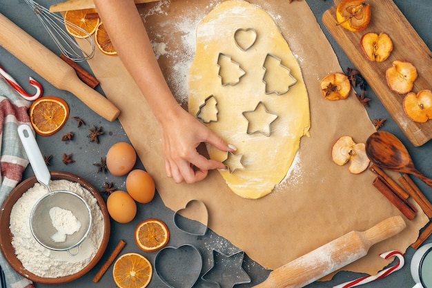 manos femeninas haciendo galletas de masa fresca en casa