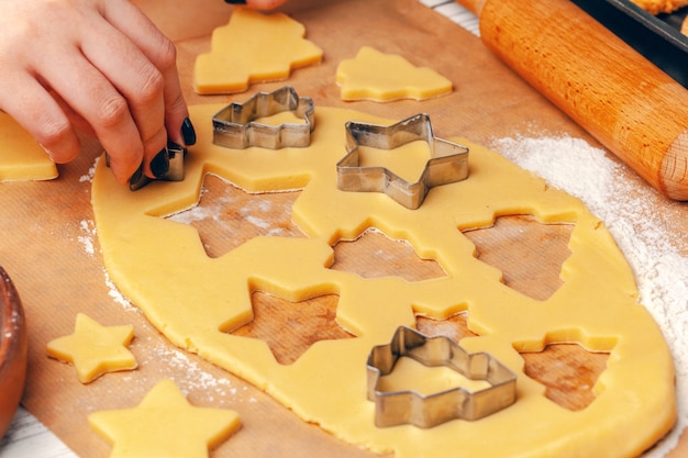 manos femeninas haciendo galletas de masa fresca en casa