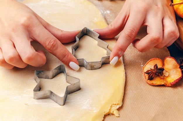 manos femeninas haciendo galletas de masa fresca en casa