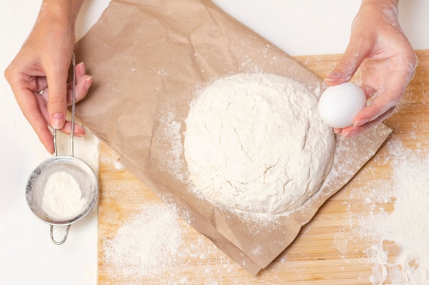 Manos femeninas haciendo masa para pizza