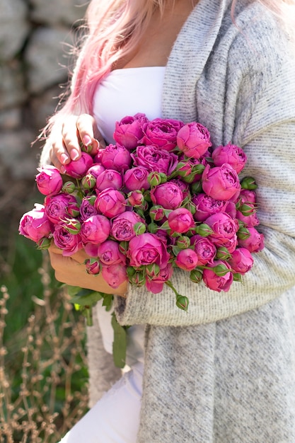 Manos femeninas con hermosas rosas y peonías