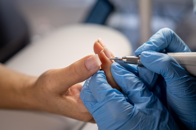 Manos femeninas y herramientas para el proceso de manicura de realizar manicura.