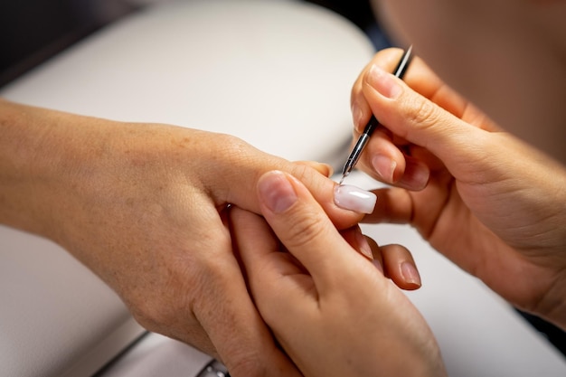 Manos femeninas y herramientas para el proceso de manicura de realizar manicura.