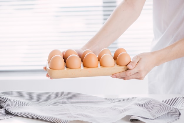 Manos femeninas con huevos de gallina.