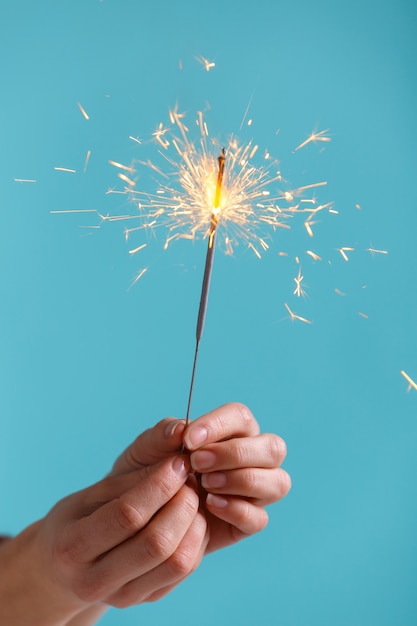 Manos femeninas con luz de bengala.