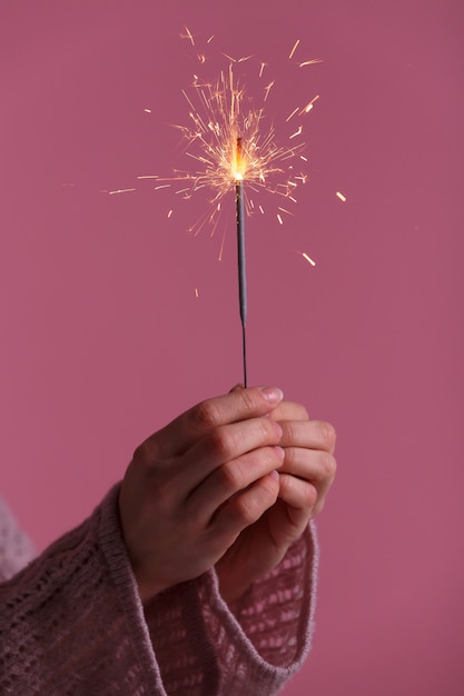 Manos femeninas con luz de bengala.