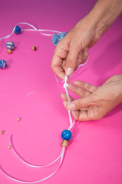 Las manos femeninas del maestro ensamblan un producto hecho a mano con lana afieltrada