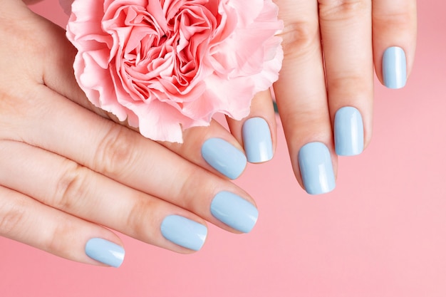 Manos femeninas con manicura en flor