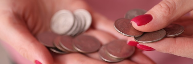 Manos femeninas con manicura roja contando monedas de cerca. Concepto de gastos de bolsillo