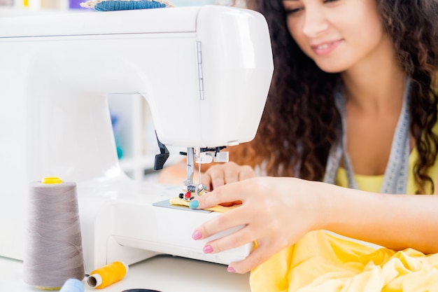 Manos femeninas en la máquina de coser