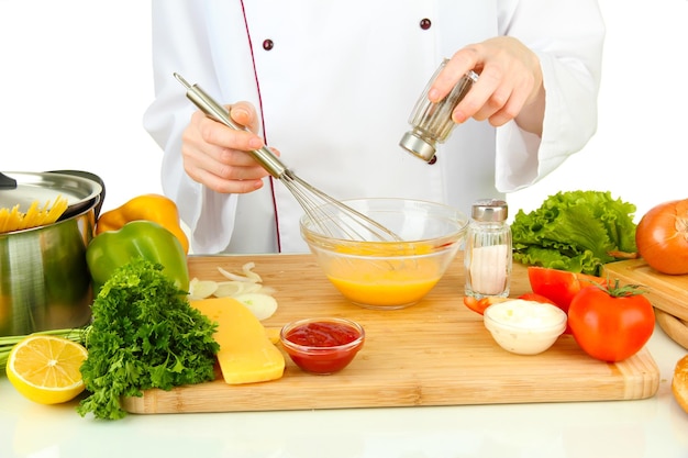 Manos femeninas mezclando huevos en recipiente de vidrio