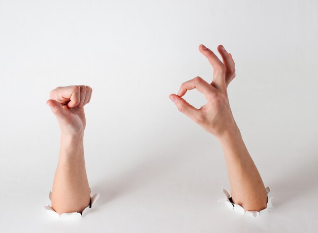 Manos femeninas mostrando el pulgar hacia arriba y el símbolo ok