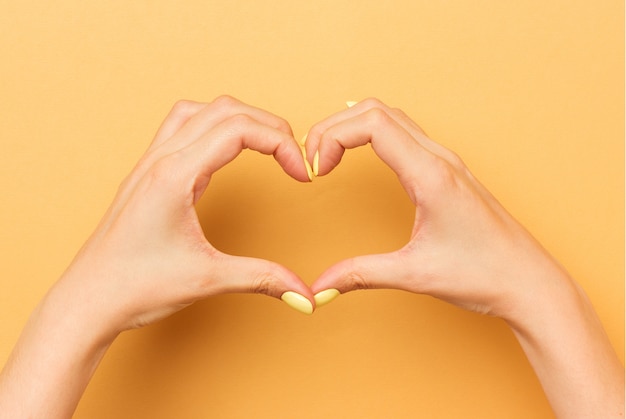 Las manos femeninas muestran un símbolo de corazón aislado.