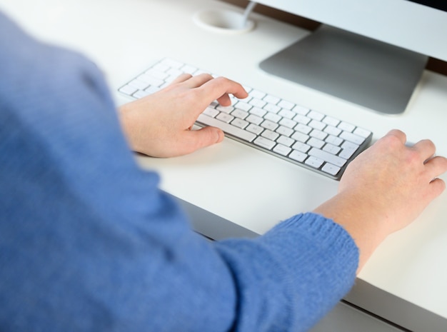 manos femeninas en la oficina, en casa, trabajando con el teclado