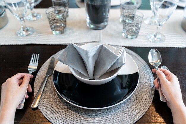 Manos femeninas con plato vacío para comida esperando