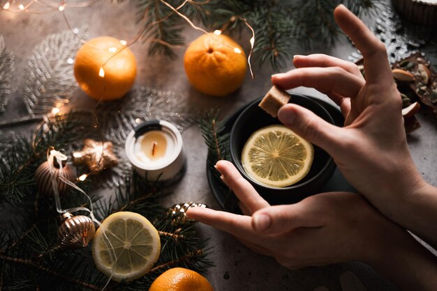 manos femeninas ponen terrón de azúcar en el té, ambiente de año nuevo