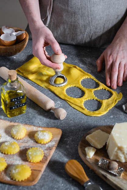 Manos femeninas, proceso de preparación de pasta italiana casera, ravioles