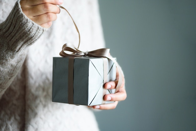 Manos femeninas que abren la caja de regalo, espacio de la copia. Navidad, año nuevo, concepto de cumpleaños.