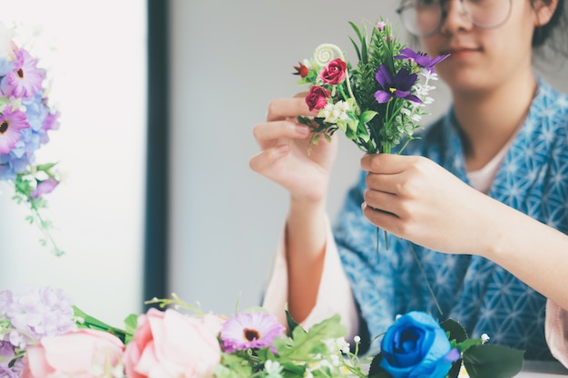 Manos femeninas que hacen hermosa composición de flores en tienda de flores