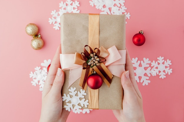 Manos femeninas que se sostienen presentes con el arco en rosa. Telón de fondo festivo para vacaciones: cumpleaños, día de San Valentín, Navidad, año nuevo. Lay Flat