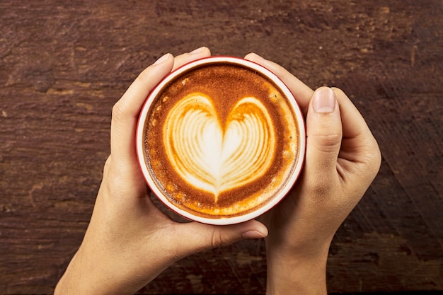 Manos femeninas que sostienen una taza de café