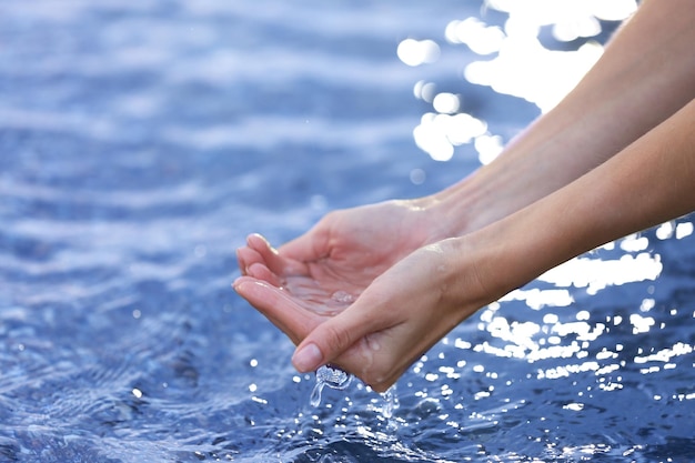 Manos femeninas que tocan el agua de mar