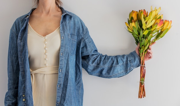 Manos femeninas con ramo de leucadendron