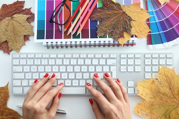 Manos femeninas sobre una mesa con manicura roja de cerca