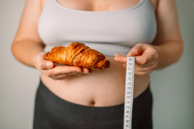 Foto manos femeninas sosteniendo manzana verde con cinta de medición gris aislada sobre fondo blanco pérdida de peso