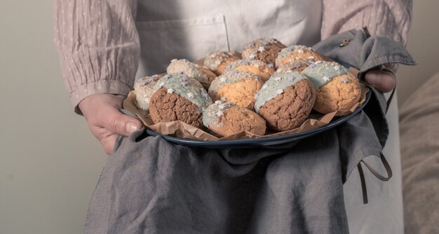 Manos femeninas sosteniendo un plato con galletas para Baby shower Party