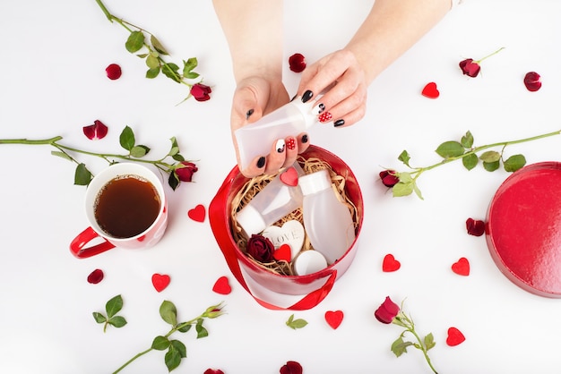 Manos femeninas sosteniendo un tubo de crema.